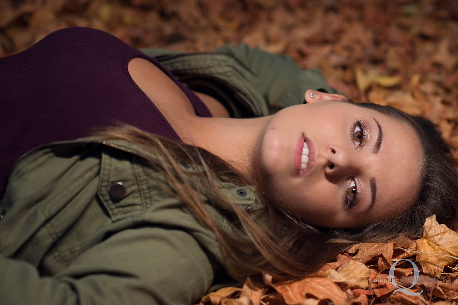 senior photo in leaves on grass