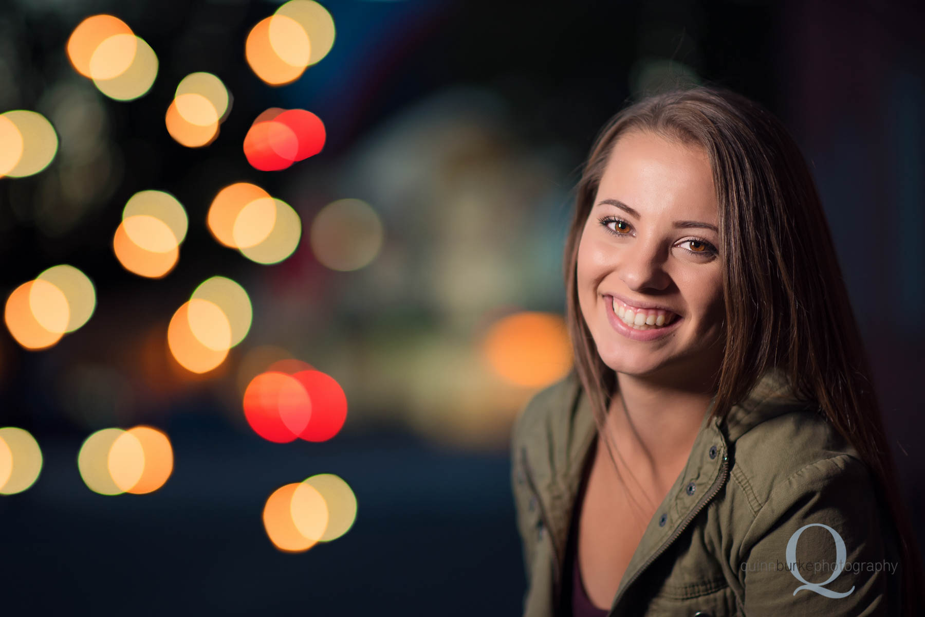 senior portrait with colorful lights in background